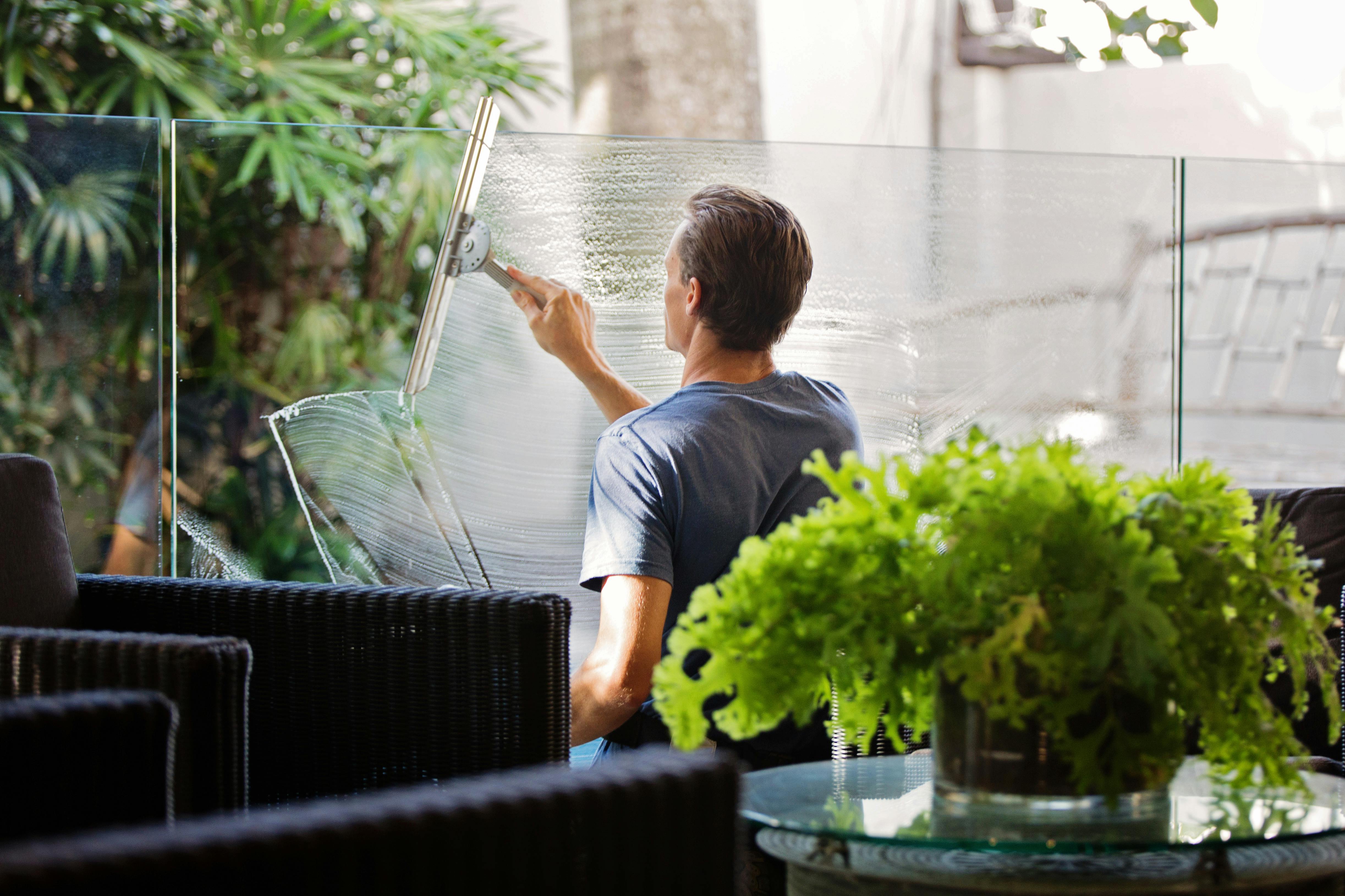 Image of man cleaning office balcony glass